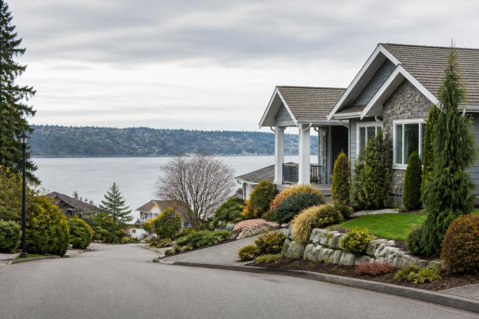 A tidy Des Moines neighborhood with evergreen landscaping and soft light.